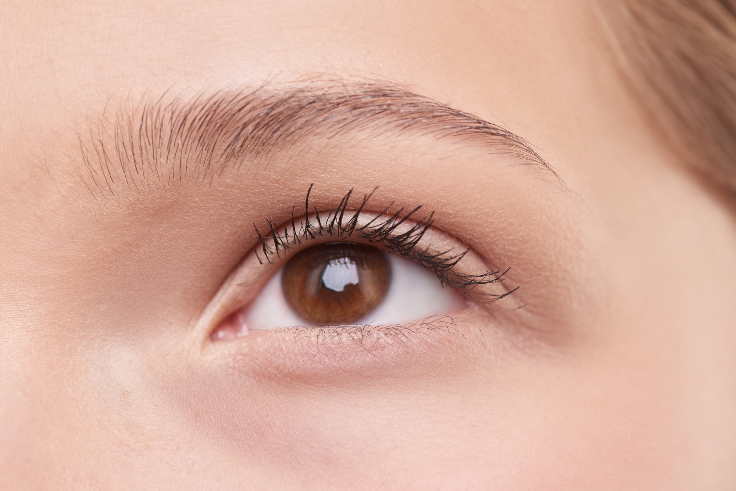 Vista de cerca del ojo de una mujer tras aplicar contorno de ojos antiarrugas